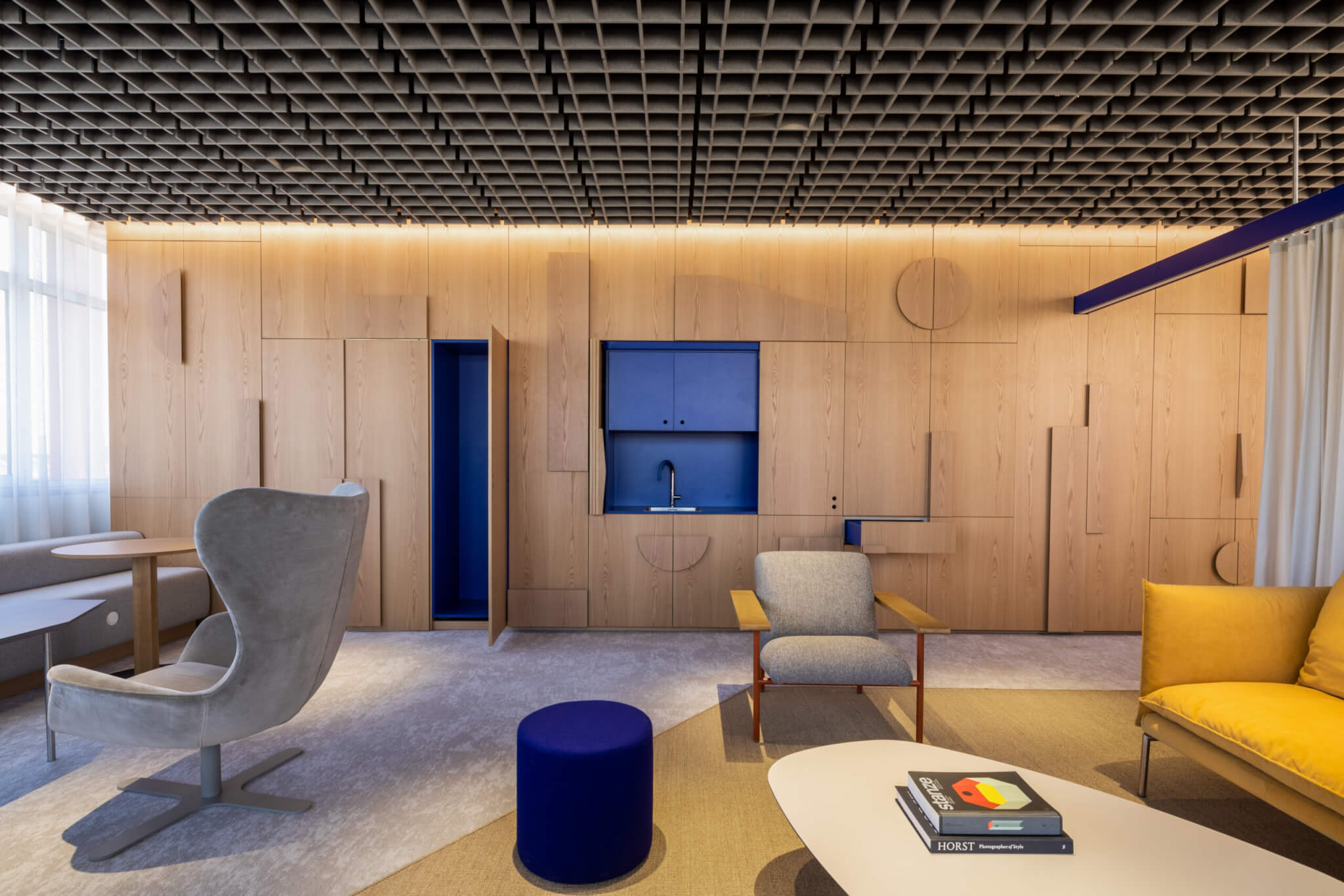 A lounge with a sound-absorbing grid ceiling. Thanks to the simple installation concept of the EchoGrid®, individual grid elements can be inserted into the specified grid structure without tools.